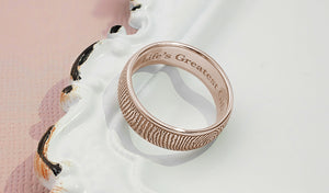 rose gold ring engraved with a fingerprint on the outside of the band and a short inscription on the inside