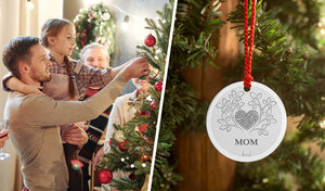 family hanging a personalized keepsake christmas ornament engraved with a fingerprint and the name mom on the tree