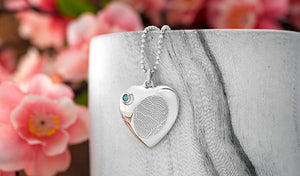 sterling silver heart shaped cremation urn necklace engraved with a fingerprint with a blue swarovski birthstone closure