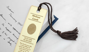 fingerprint bookmark in brass engraved with a name, dates, and custom inscription