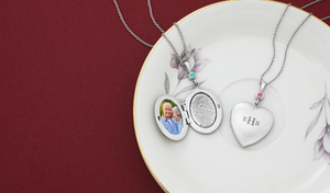 sterling silver oval locket with photo and engraved fingerprint on inside along with a sterling silver heart locket with a monogram engraved on the outside