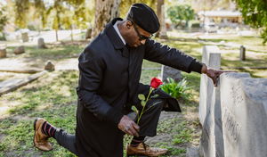 man kneeling at a grave