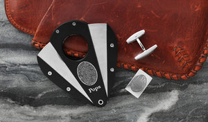 custom xikar cigar cutter engraved with fingerprint and name "Pops" sitting next to stainless steel cufflinks for men engraved with a fingerprint