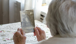 person holding an old photo of their sibling