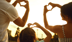 family holding their hands in a heart shape