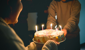 someone handing a family member a birthday cake