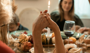 family holding hands at a thanksgiving table